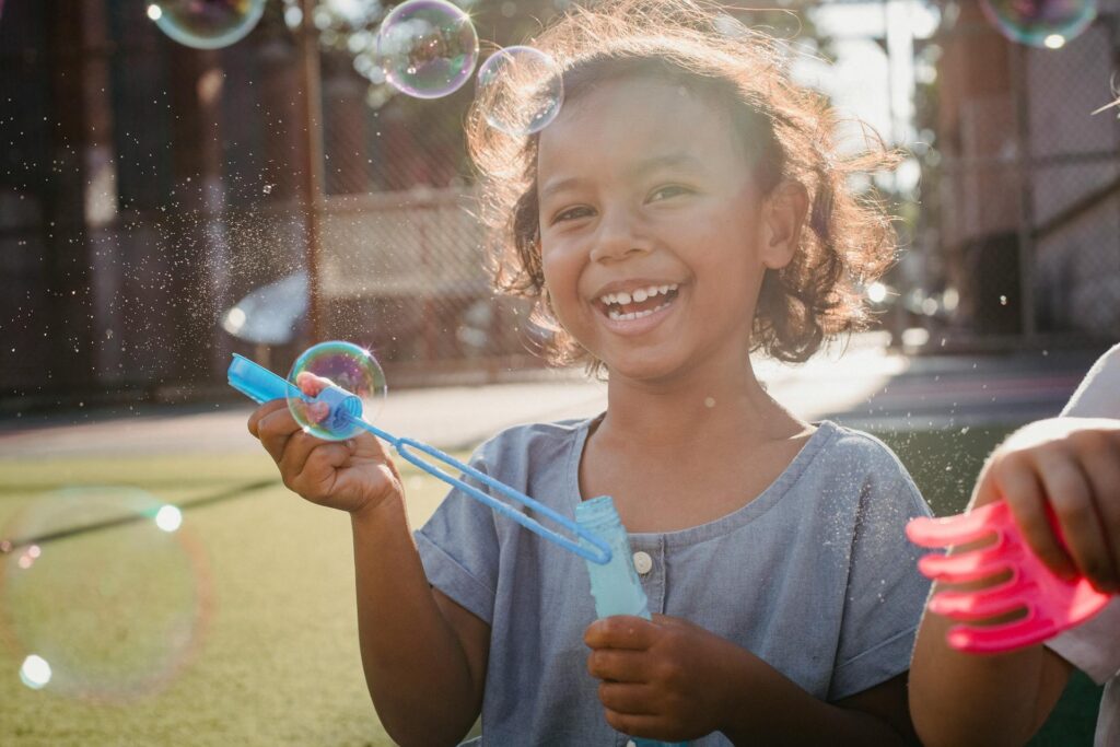 A young child smiling outdoors, representing the hope and the goal of returning to a healthy, happy baseline.